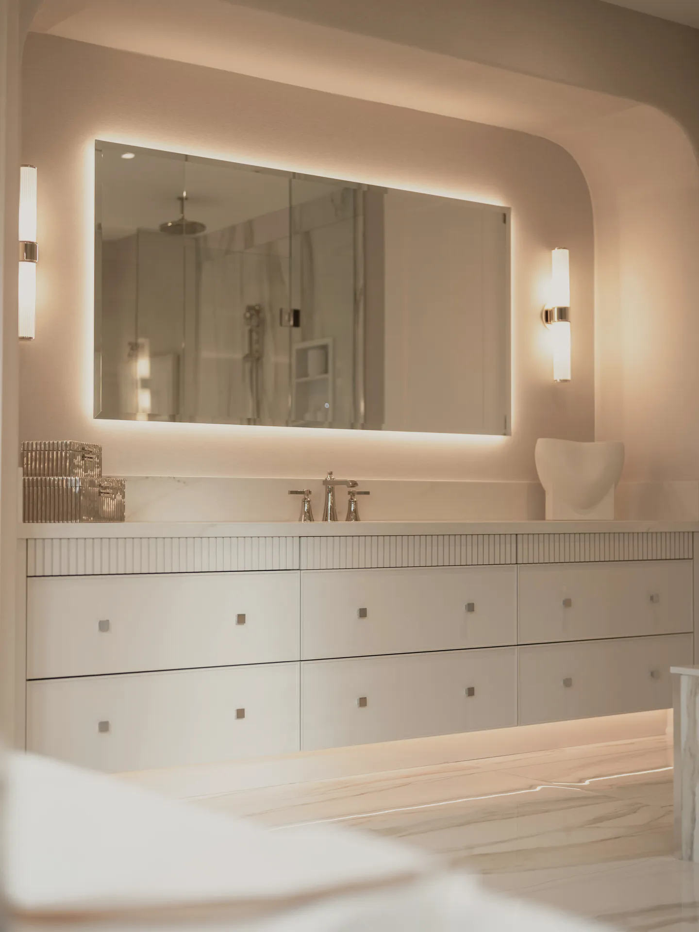 The double vanity under a lit mirror