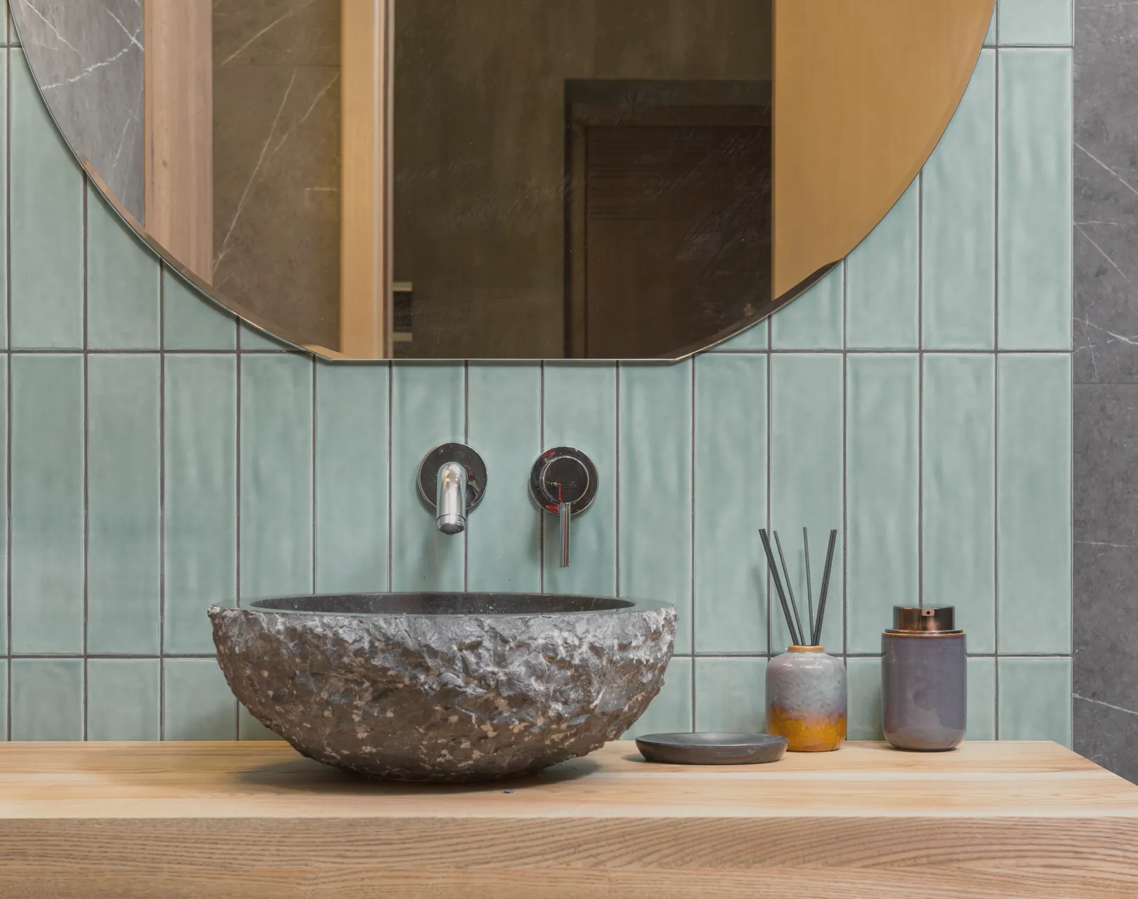 The basin beside the green tiled wall