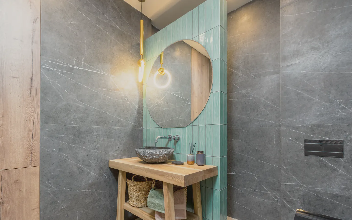A green tiled bathroom with a stone basin on an oak stand