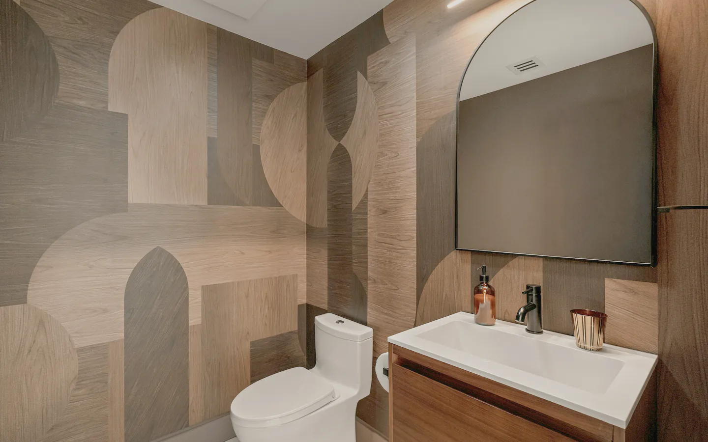 A powder room with geometric timber panels and a wall hung basin
