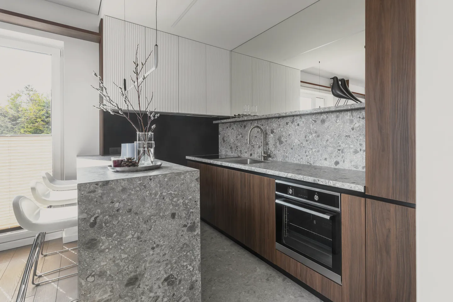 The kitchen’s dark cabinets and stone benches