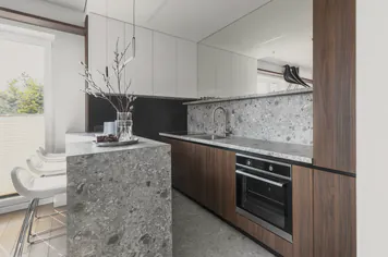 The kitchen’s dark cabinets and stone bench