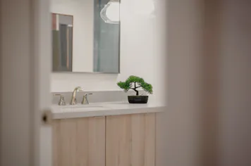 A vanity and brass mixer seen through a doorway