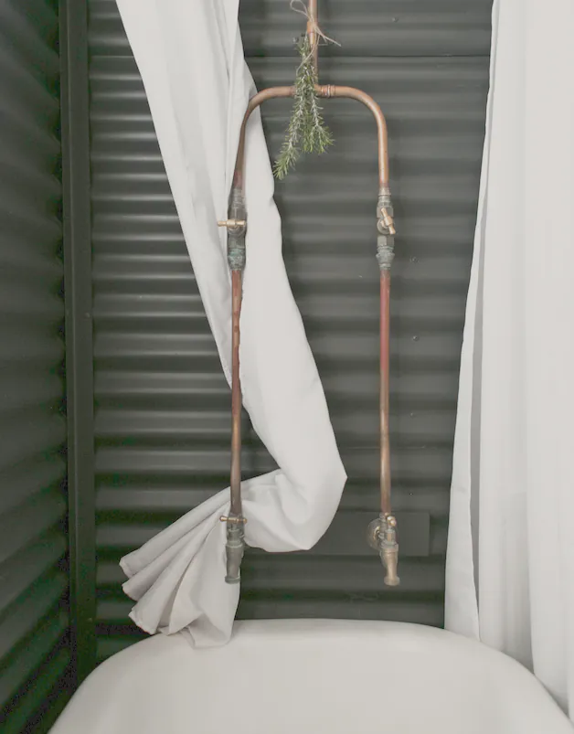 Exposed copper over a clawfoot bath