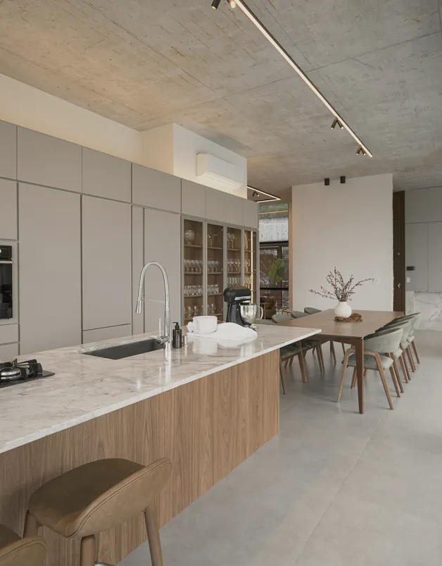 A walnut island under a concrete ceiling