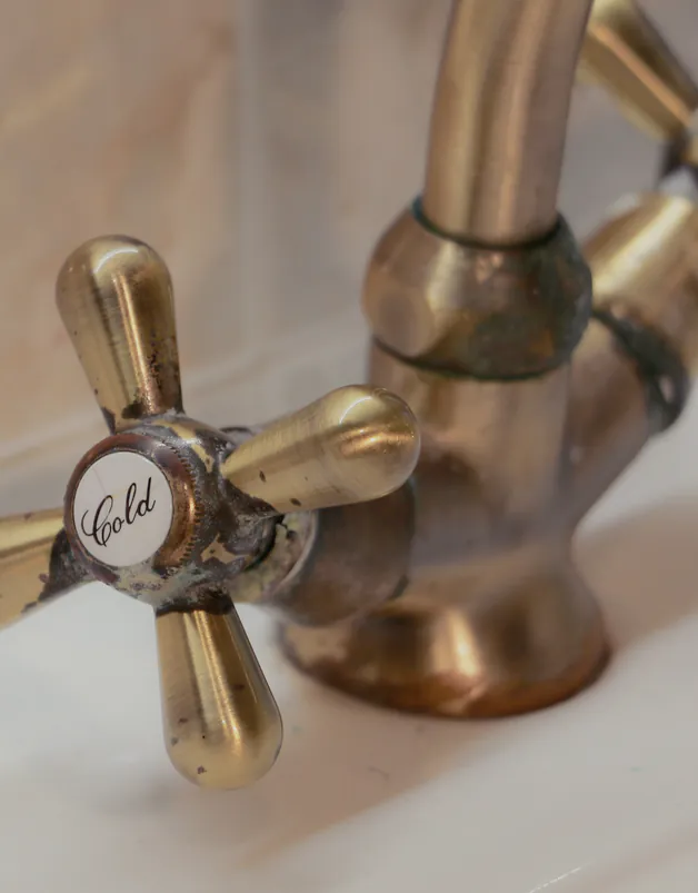 A brass wall mixer over the basin