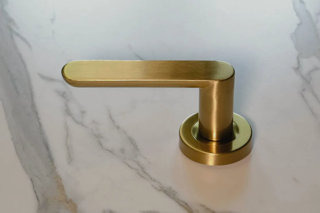A brass mixer lever set on marble