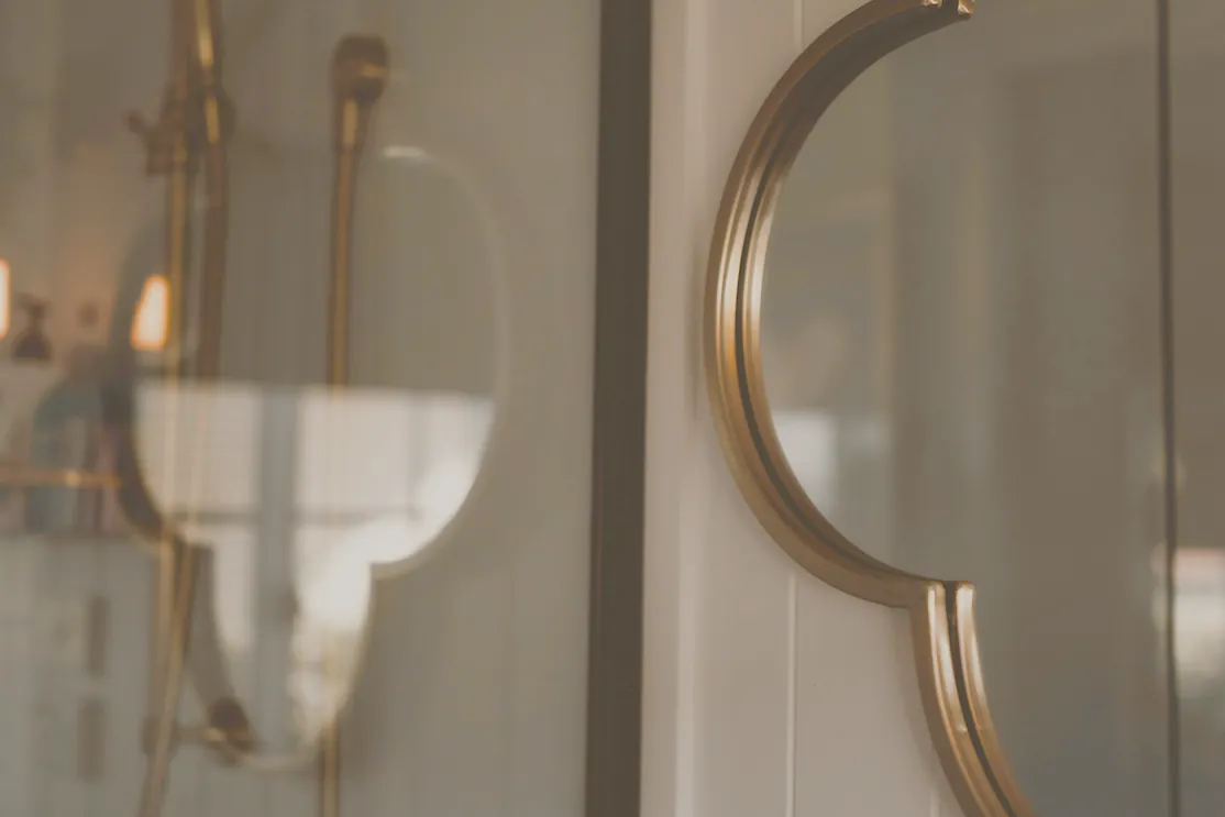 A brass shower rail in a dark panelled ensuite