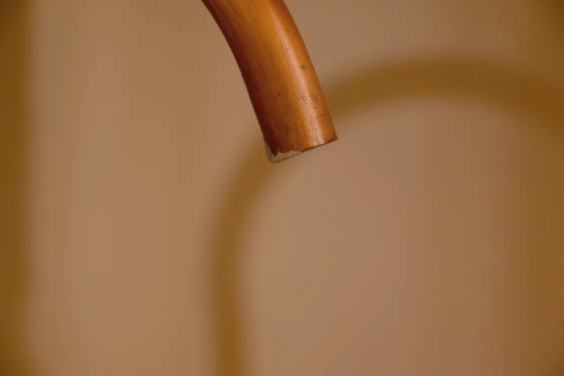A copper bend against warm light