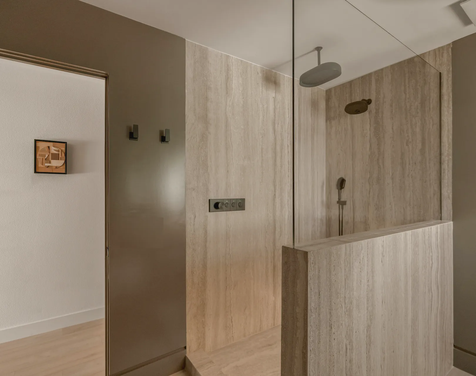The walk in shower behind its glass screen