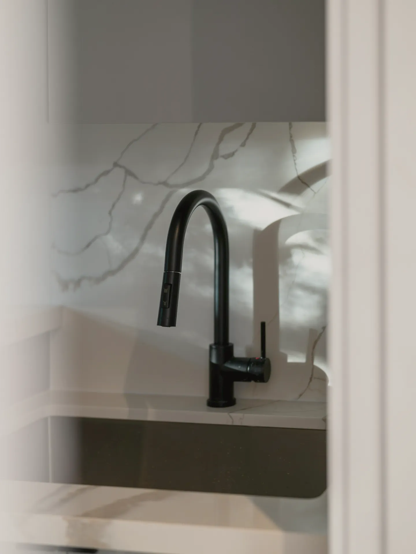 A black kitchen mixer on marble